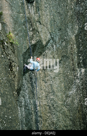 Woman down the slate rock face of Cathedral Quarry in Little Langdale, Lake District National Park, Cumbria, England Stock Photo