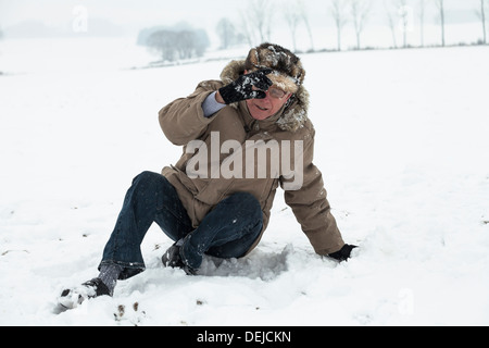 Senior man accident falling on snow in winter. Stock Photo