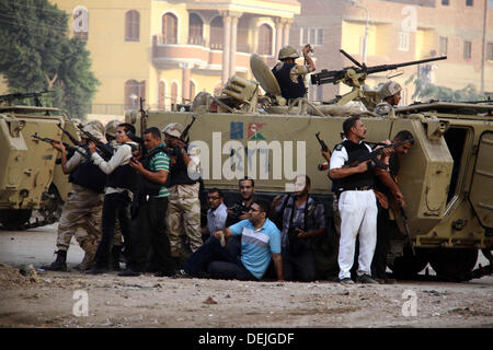 Cairo, Egypt. 19th Sep, 2013. Egyptian soldiers take cover behind an armoured personnel carrier as they keep watch during an operation against gunmen in the Kerdasa district in Giza. An Egyptian police general has been killed in clashes between Islamist gunmen and security forces storming a village, security officials said. © Ahmed Asad/APA Images/ZUMAPRESS.com/Alamy Live News Stock Photo