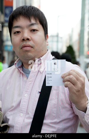 People line up to buy iPhone Duo handsets at an Apple Store in Hangzhou ...