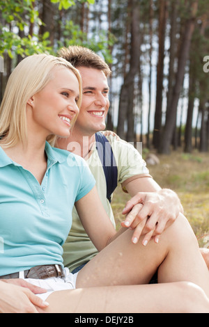 Thoughtful hiking couple looking away while relaxing forest Stock Photo