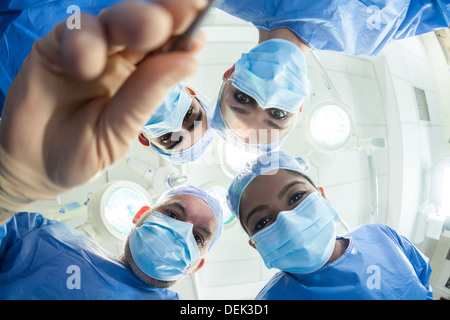 Interracial male female medical hospital doctors surgeons surgical team operating theater performing surgery on a patient Stock Photo