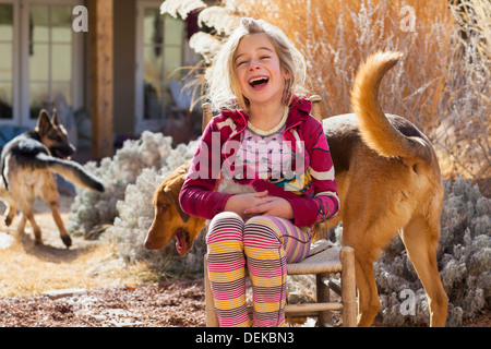 Caucasian girl sitting with dog outdoors Stock Photo