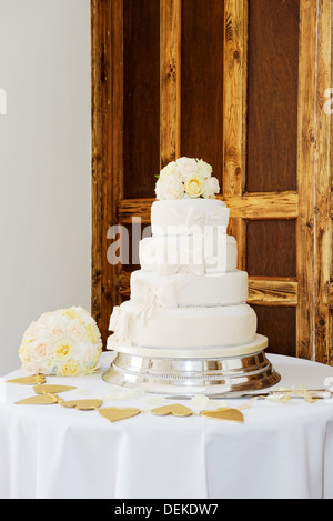 Wedding cake and brides bouquet of flowers at reception Stock Photo