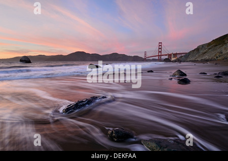 Golden Gate Bridge after sunset with red clouds and purple water Stock Photo