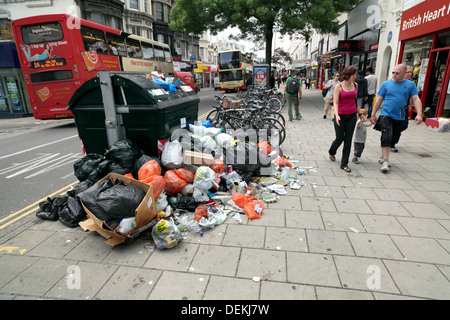 Rubbish piled around an overflowing skip of litter, Brighton. Stock Photo