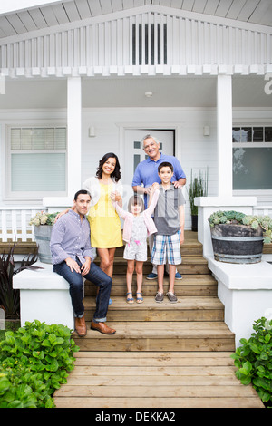 Family smiling together on porch Stock Photo