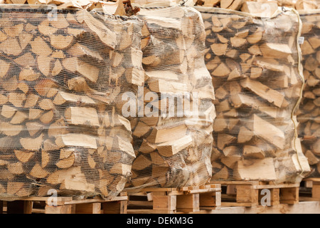 Packed stacks of fire wood laying on palettes in the market Stock Photo