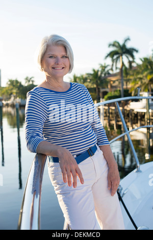 Mature woman standing on yacht, smiling Stock Photo - Alamy