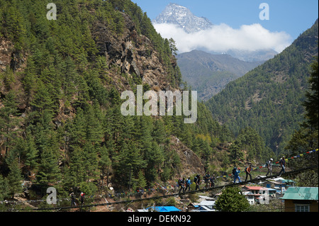 Trekkers cross the Dudh Kosi River on their way to/from Namche Bazaar on the Sir Edmund Hillary Bridge, Himalayas, Nepal Stock Photo