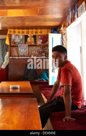 Sherpa porter relaxes in a tea house en route on the trail from Phagding to Namche Bazaar, Everest region, Nepal Stock Photo