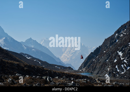 Helicopter flies North through the valley towards Gokyo, Nepal.Could be for rescue or a tourist flight for views from the air Stock Photo