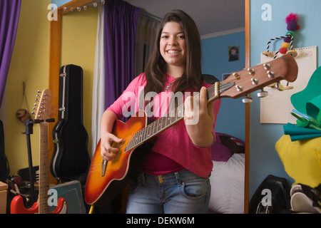 Hispanic girl playing guitar Stock Photo