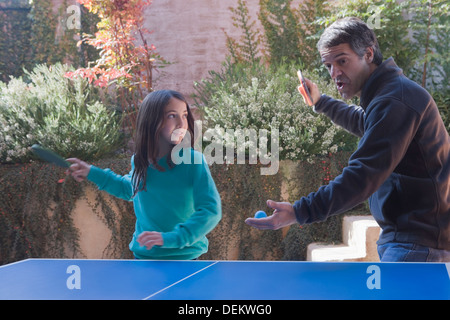 Hispanic father and daughter playing ping pong Stock Photo
