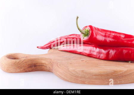red chili on the chopping board in white background. Stock Photo