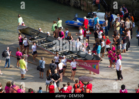 Women's rowing teams come to shore after the San Sebastian regatta in the Basque country. Stock Photo