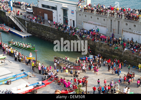 Women's rowing teams come to shore after the San Sebastian regatta in the Basque country. Stock Photo