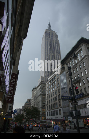 Looking south on 5th ave.towards 34th Street with the Empire Stae Building looming up into a stormy sky. Stock Photo