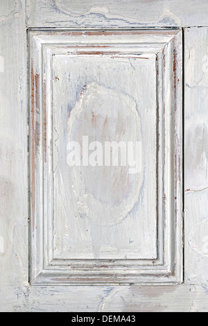 Old distressed wood door panel with peeling paint as framed background Stock Photo