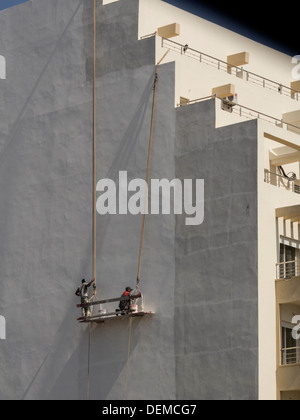 Construction workers painting outer building wall Stock Photo