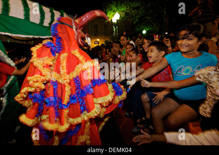 Costumed revelers called vejigantes greet children during the Carnaval de Ponce February 21, 2009 in Ponce, Puerto Rico. Vejigantes are a folkloric character representing the devil. Stock Photo