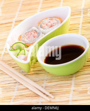 Fresh tasty sushi on bamboo tablecloth in luxury japanese restaurant, decorated with cucumber and ginger Stock Photo