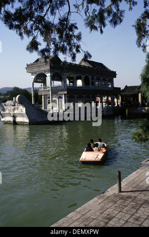 Chinese tourists boating next to the Marble Boat also known as the Boat of Purity and Ease a lakeside pavilion in Kunming Lake on the grounds of the Summer Palace in Beijing, China. Stock Photo