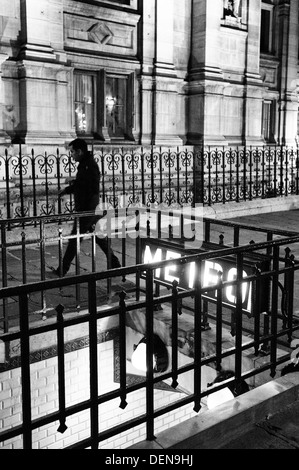 Man walking past the Hôtel de Ville Metro entrance at night, Paris. Stock Photo