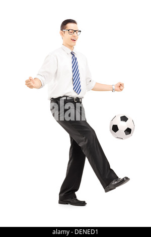 Full length portrait of a handsome male with tie and shirt playing with a soccer ball Stock Photo