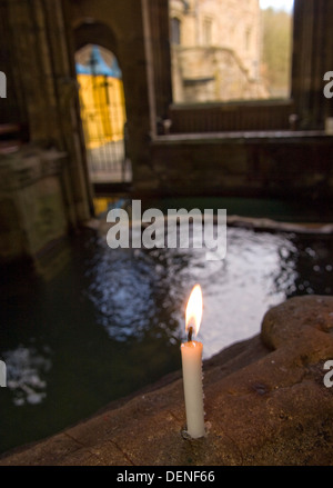 St.Winefride's Well,a holy site where a spring brings water from the hillside for bathing by a devout oriental man.a Wales UK Stock Photo