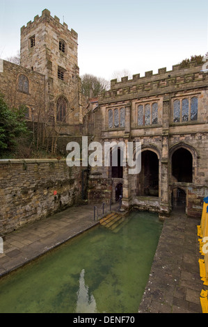 St.Winefride's Well,a holy site where a spring brings water from the hillside for bathing by a devout oriental man.a Wales UK Stock Photo