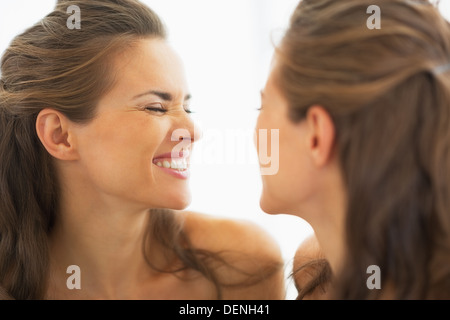 Happy young woman making funny face in mirror Stock Photo