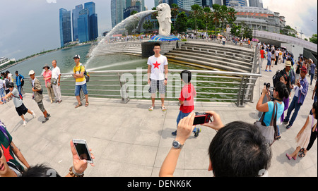 19.07.2019, Singapore, Republic of Singapore, Asia - Tourists pose in  Merlion Park on the banks of the Singapore River for photos with the  business district in the background. [automated translation] Stock Photo -  Alamy