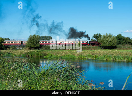 Nene Valley Railway train passes over the Nene river on a bright summers' day. Stock Photo