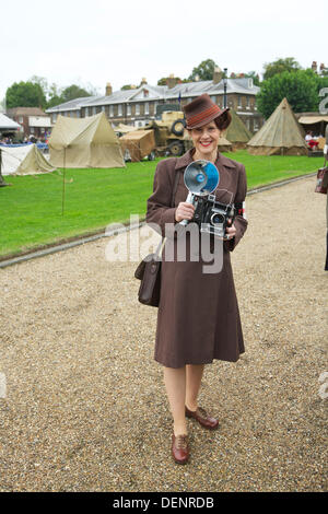 Chatham, UK. 21st Sep, 2013. Salute to the 40's - Britain's 1940's Home Front Event at The Historic Dockyard Chatham. Female press photographer with military encampment in the background. woman with camera 1950s Stock Photo