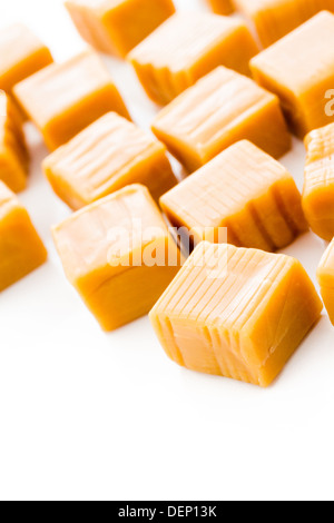 Vanilla caramel candy unwrapped on a white background. Stock Photo