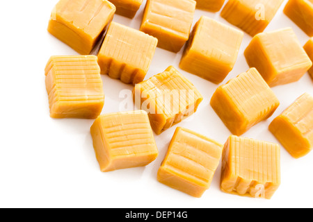 Vanilla caramel candy unwrapped on a white background. Stock Photo