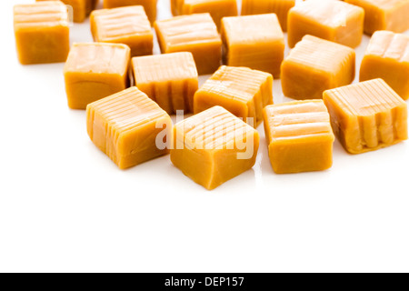 Vanilla caramel candy unwrapped on a white background. Stock Photo