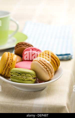 colorful macaroons in bowl on kitchen table Stock Photo