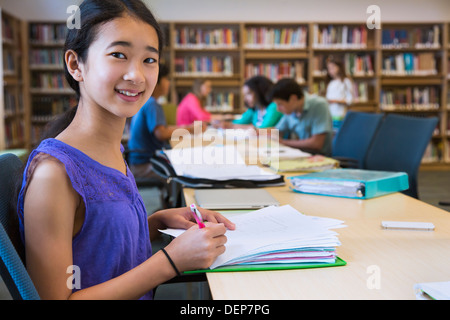 Student taking notes in library Stock Photo