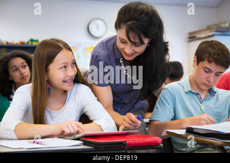 Teacher helping students in class Stock Photo