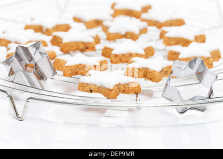 many christmas cinnamon stars on a cooling grid with metal molds Stock Photo