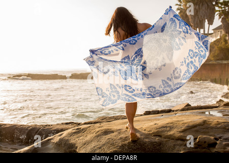 Japanese woman holding sarong on beach Stock Photo