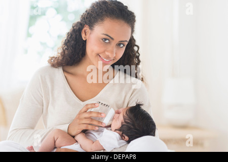Hispanic mother bottle feeding infant son Stock Photo