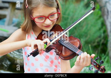Hispanic girl playing violin outdoors Stock Photo