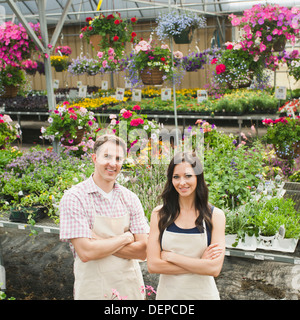 Caucasian workers smiling in plant nursery Stock Photo
