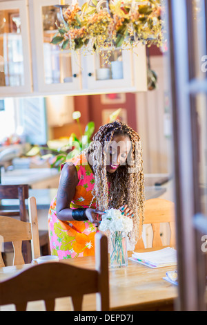 African American woman arranging bouquet of flowers Stock Photo