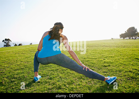 Mixed race woman stretching in park Stock Photo
