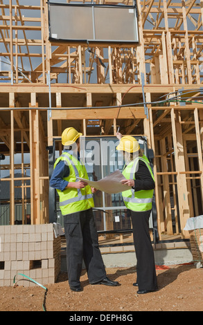 civil engineer and worker discussing issues at the construction site Stock Photo