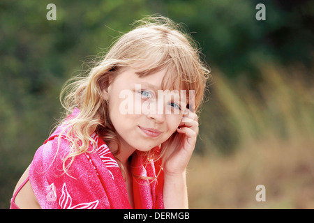 Outdoor summer portrait of Little blond Caucasian girl in red shawl Stock Photo
